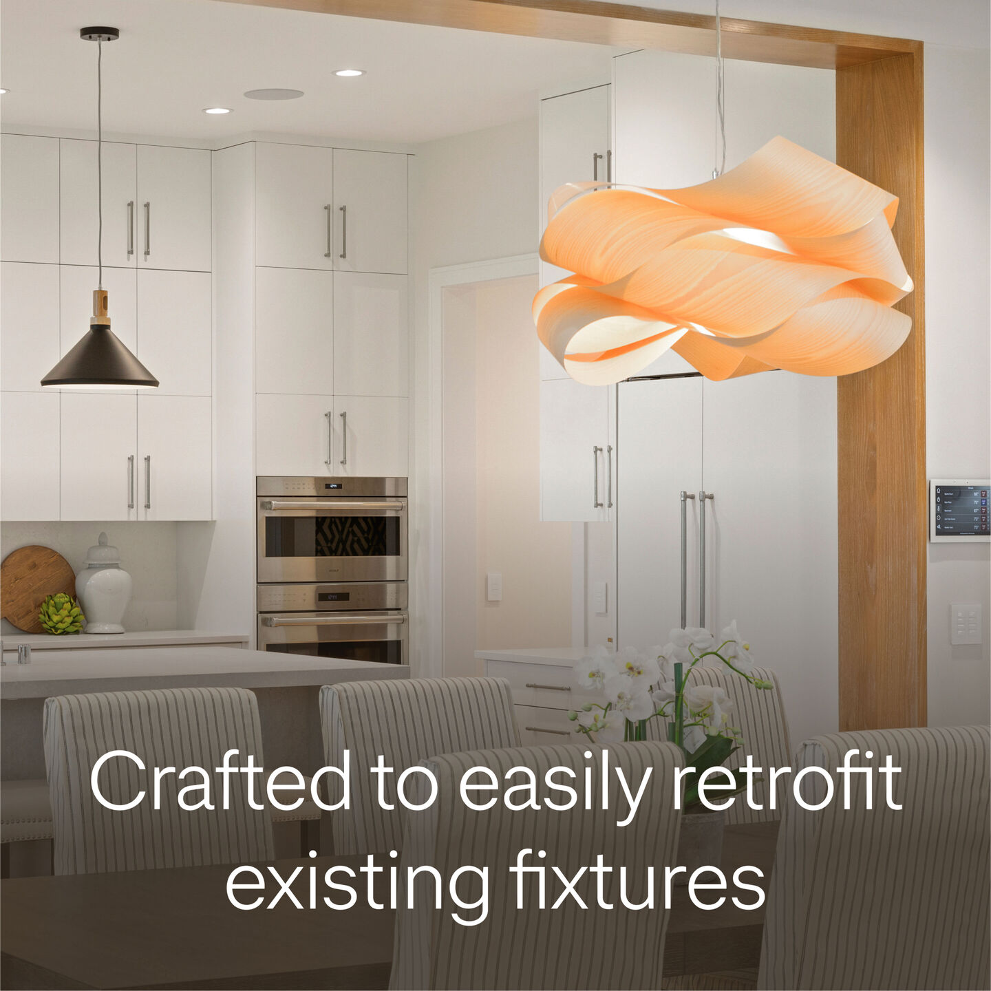 Modern kitchen with pendant lighting and a sculptural ceiling fixture, with text “Crafted to easily retrofit existing fixtures”