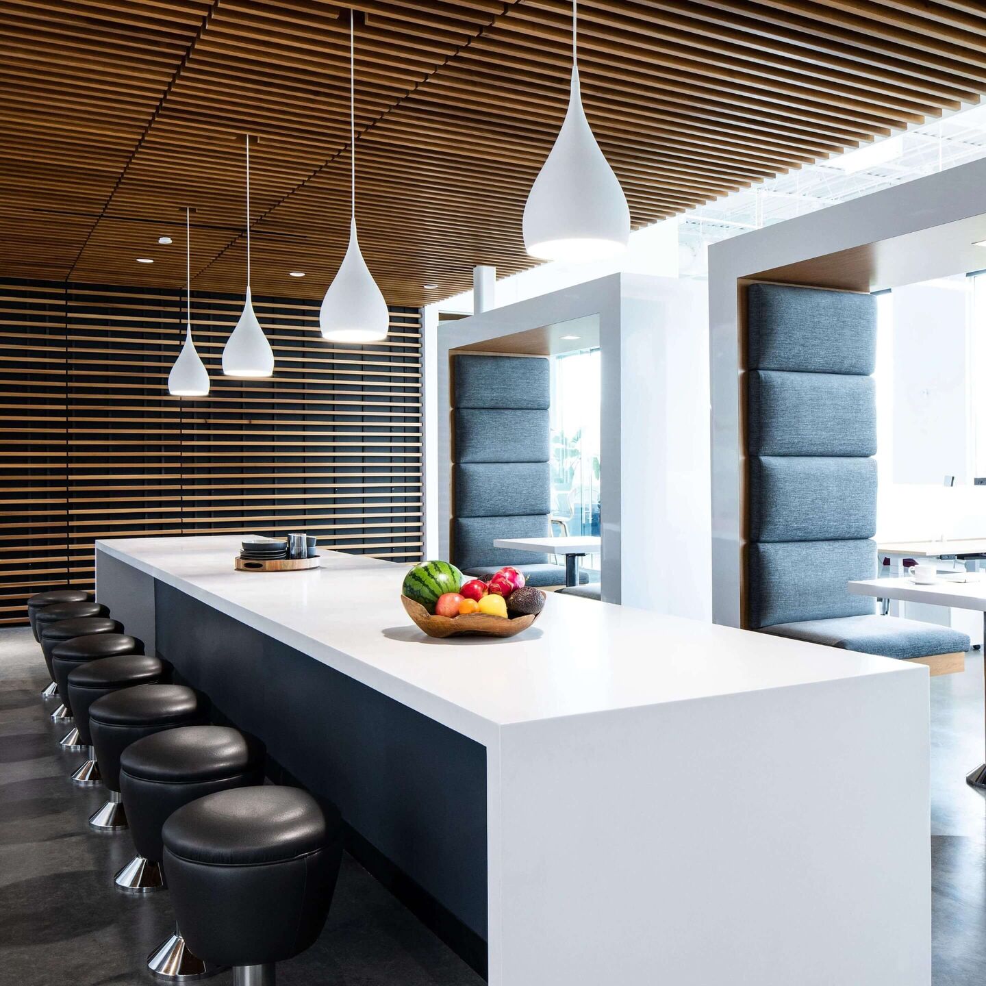 Contemporary kitchen illuminated by sleek pendant lights over island with complementary ambient and task lighting throughout